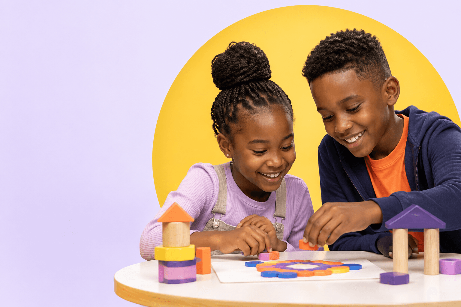 Two Kenyan children smiling as they solve a colourful pattern activity together